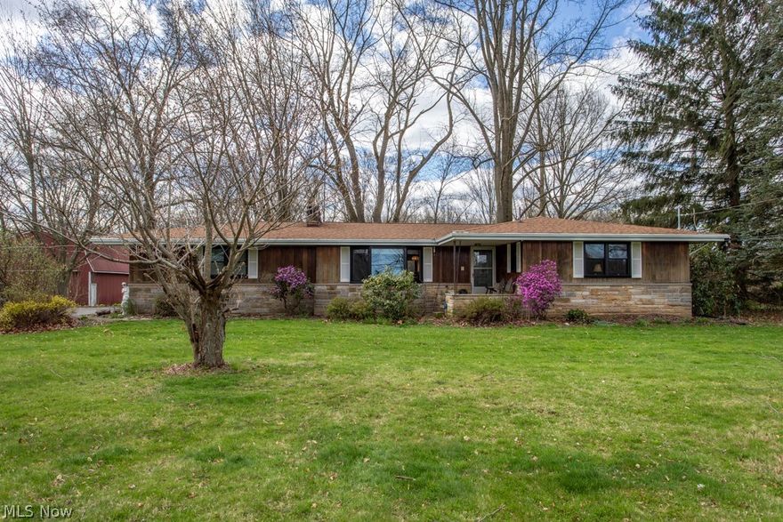 Embrace the beauty of rural living in this inviting ranch-style property on 5 acres of serene surroundings. This charming home boasts 15 brand-new black Pella windows, three bedrooms and two full bathrooms. The master bedroom has a half bath connected for your comfort. The spacious living room with original hardwood floors features a large beautiful stone fireplace. The partially finished basement, offers flexible living space with a brick fireplace. Outside, enjoy a remarkable variety of hostas, peonies, tulips, daffodils and giant lilies. In the side yard you'll find peach trees, pear trees, a strawberry and asparagus patch as well as raspberry and blackberry bushes. The yard has been thoughtfully landscaped throughout. For those with a green thumb or a passion for sustainable living, the property includes a running water stream and a chicken coop, allowing you to indulge in farm-fresh eggs and embrace the joys of rural living.  The large barn provides two stories of storage area that can be used for equipment or livestock. There are also additional rooms on the side of the barn that can serve as a work shop. Don't miss out – schedule your tour today!