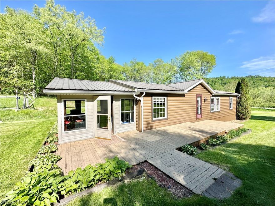 Welcome to your serene countryside retreat! This charming modular home, designed with the rustic appeal of a log cabin, is nestled on nearly an acre of picturesque land. The home features three spacious bedrooms and three full baths, providing ample space and comfort for your family.
Step inside to discover an updated kitchen with modern amenities, perfect for culinary adventures, and beautiful new flooring throughout the home. Enjoy the natural light and tranquility in the enclosed sunroom, a perfect spot for morning coffee or evening relaxation.
The property boasts a massive utility barn, ideal for storage or workshop needs. Additionally, there's a large chicken coop that offers versatile potential; it can be easily converted into extra living space for any kind of animal.
Adding to the property's charm is a natural spring. Experience the perfect blend of rustic charm and modern comforts in this unique rural haven. Don't miss out on this exceptional property!