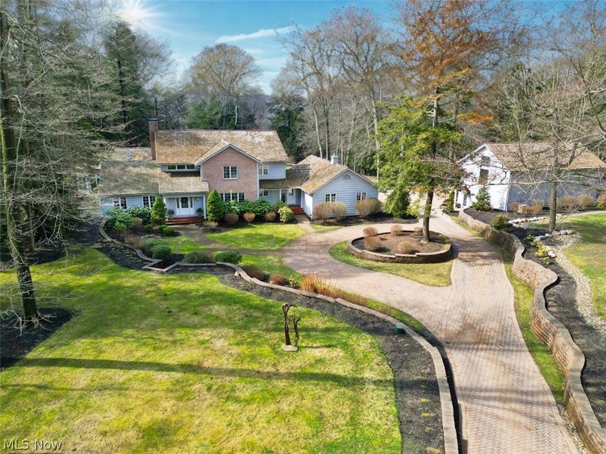 Set on over 10.5 acres of beautifully landscaped grounds with a winding picturesque driveway, this exceptional property unfolds in a setting that feels straight out of a storybook. The grounds are truly remarkable and feature an inground pool, patios, a greenhouse, gazebo, and a deck overlooking a peaceful ravine. It is a setting that feels private, scenic, and incredibly special. The main residence offers a first floor primary wing with a bedroom that opens to the patio, a spacious bathroom, two separate walk in closets, and an exercise or bonus room with views of the private yard. An adjoining office with a fireplace connects to the bedroom, creating a comfortable and private retreat. The main level is designed for both entertaining and relaxed living with a large kitchen and eating area overlooking the yard, a formal dining room, a family room with a fireplace, and a welcoming living room just off the foyer. Two half baths complete the main level. Upstairs are three bedrooms and two full baths. The lower level offers additional living space with a large recreation room, full bath, and a wine cellar. The property also includes a charming carriage house that offers wonderful flexibility for guests, extended stays, or private living space. Outfitted with a full kitchen, living room, bedroom, and full bath, it provides comfort and privacy while still feeling connected to the estate. Between the main house and carriage house there are six heated garage spaces, three in each home. This is a truly extraordinary property offering privacy, space, and a setting that is difficult to replicate. Close proximity to main roads, I-271, Hillcrest Hospital, upscale shopping, and fine dining! Some of the most prestigious private schools in Cleveland are located just minutes away!