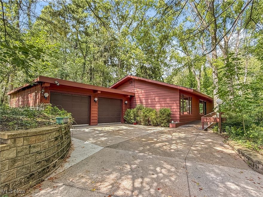 Mid-century modern style with walls of windows that frame gorgeous wooded views, yet you’re still in the city. This 3-bedroom home includes a primary suite with a walk-in closet, plus a first-floor office with two built-in desks that could be a 4th bedroom. The combination living/dining room centers around a floor-to-ceiling stone fireplace. A full bathroom with shower are also on the main level. A large wraparound deck extends along three sides of the home, with an oversized section perfect for entertaining. Downstairs, the family room offers a second fireplace and sliding doors to the outdoors. The two secondary bedrooms are in the lower level along with a full bath that includes a tub. All appliances are included, and a two-car attached garage (no direct entry to the home).