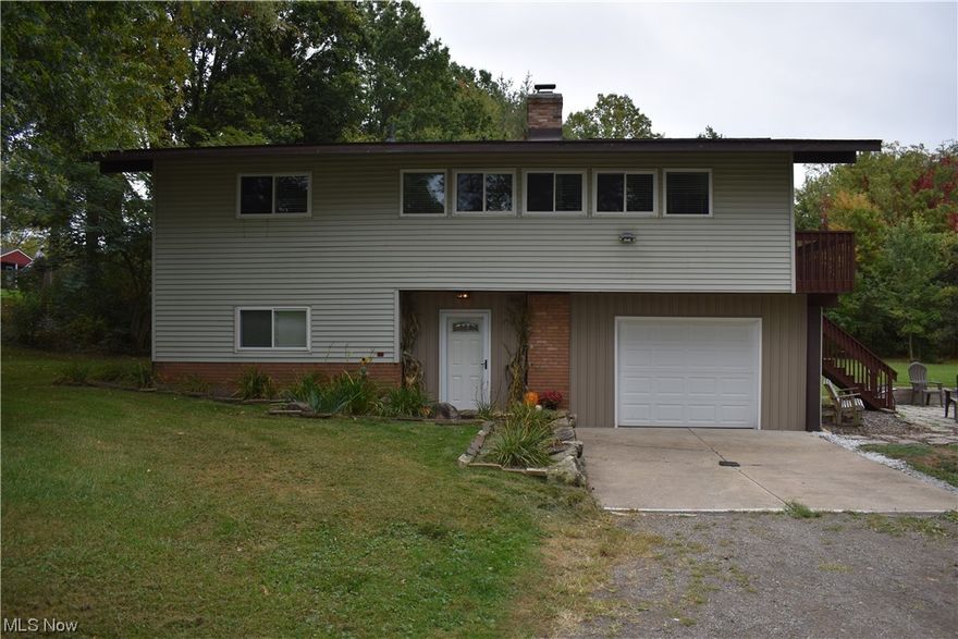 Beautiful split-level home nestled on a dead-end street on .68 acres in Suffield Township close to schools, shopping, dining, entertainment & more. Walk through the front door & find a cozy custom-made bench with cupboards to store coats, boots, & backpacks. To the left is a hallway leading to a bedroom, full bath, bonus room, laundry room (washer/dryer do not convey), and access to the oversized 2-car garage. The newly remodeled bathroom (2023) has a vanity with modern sink, and shower. The bonus room is a blank slate for the new owner that can be used as a guest bedroom, office, play area, gym, or media room! Upstairs to the right is the living room/dining room area with breathtaking view of the yard, vaulted ceiling, hardwood floors, wood-burning fireplace, & access to the deck. The dining area leads to the galley-style kitchen with SS appliances, SS sink, formica countertops, & oodles of cupboard/counter space. All kitchen appliances convey. Kitchen leads to hallway with two bedrooms & newly remodeled bath. Both bedrooms are carpeted with hardwood floors underneath and large closets. Bathroom has a double sink, vanity with a great deal of storage, & tub/shower combination. The deck embraces two sides of the house with stairway down to private, paved patio area surrounded by above-ground planting boxes. There are two sheds on the property as well. OPEN HOUSE CANCELLED!