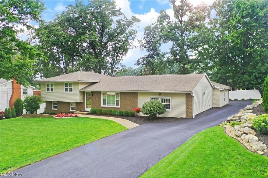 Get ready to fall in love with this breathtaking Howland split level, showcasing three floors of gorgeous living space and a masterfully landscaped yard! Set in a desirable local neighborhood, this home packs a curb appeal punch with its brick façade and accenting stonework that lines the driveway, giving way to a large turn around before the rearward garage. Around back, the fenced yard offers park-like views, easily enjoyed from the nature-stone, covered rear patio. Through the front door, a remarkable living room is dressed in dark, hardwood styled flooring as the picture window provides plenty of natural light. Nearby, formal dining continues the wrapping chair wall and decorative wall trim as it looks on towards the Tuscan styled kitchen. Here, a glass tiled backsplash pairs with speckled granite countertops and stainless appliances as the custom cabinets extend out for additional seating. The posh family room drops away nearby with a stone trimmed fireplace and bonus coat room. Upstairs, three welcoming bedrooms bring lush carpets as they join a tastefully updated full bath and its tiled shower. The larger master suite includes its own full private bath with heavy glass work. Down below, finished rec space joins storage, a half bath and laundry access. New in 2017 includes Fireplace, Vinyl Fence, LVT flooring, Master Bathroom, Whole House paint, Landscaping, Garage Door. Nature Stone 2019,updated Kitchen and all windows 2016. 1 year Home Warranty included!