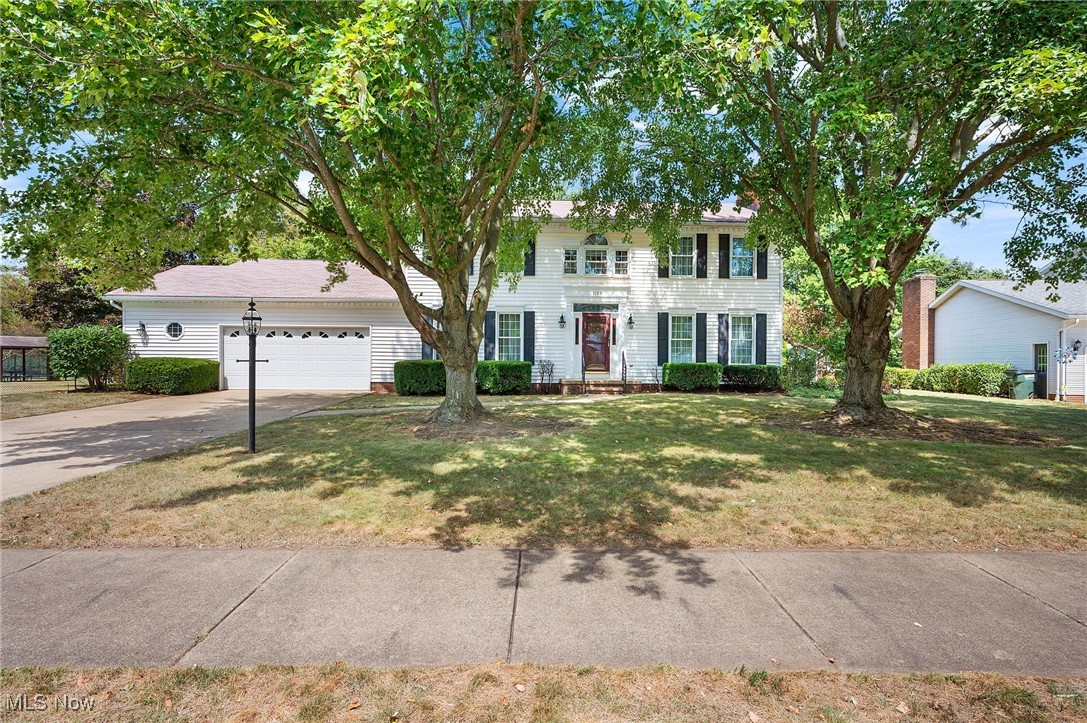 Welcome to 1129 Sprucewood St SE – A Timeless Colonial in North Canton! This beautifully maintained colonial offers over 2,500 sq ft of living space with 4 spacious bedrooms and 3 full bathrooms, perfectly blending classic charm with everyday comfort. Step inside the warm and inviting foyer, where natural light pours into the cozy living room through a set of matching windows. A charming fireplace with custom built-ins creates the perfect gathering spot, while the open flow leads seamlessly into the formal dining room—complete with a sparkling chandelier and bay window, exuding timeless elegance. The kitchen provides ample wood cabinetry, a cooktop, double wall ovens, and a dishwasher, making it both functional and welcoming. Just beyond, the family room invites relaxation with its second fireplace, accented by rich woodwork and built-ins. One of the true highlights of the home is the stunning screened porch—bathed in natural light, surrounded by windows, and offering peaceful views of the backyard, making it the perfect sanctuary for relaxation. A versatile home office and a full bath complete the main level. Upstairs, you’ll find 4 generously sized bedrooms, each with plenty of closet space, along with 1 full bathroom and a convenient second-floor laundry area. The primary suite boasts a walk-in closet and an en-suite bath, creating a private retreat. The backyard is equally impressive, featuring mature trees, lush green space, and plenty of room to enjoy the outdoors. An attached garage adds convenience to this already exceptional property. Don’t miss the opportunity to make this North Canton gem your forever home!