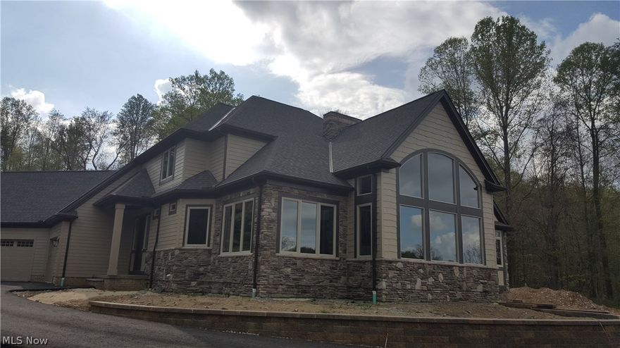 One of a Kind Custom New Construction built by Petros Homes in Hinckley is ready to move in now! Classic Country rustic elegance nestled in nature is steps over the Cuyahoga County border. First floor owner's suite plan loaded with upgrades situated on a breathtaking and private 3+ acre country lot with wooded backdrop and lake view. True custom plan with wide open great room with window wall overlooking majestic mature treed view on one side and peaceful lake view on the other. Elegant iron and wood railing to second floor. Formal dining room with trim upgrades and details. Exquisite working kitchen with wood floors, granite surfaces, wood cabinetry and designer appliances opens to large eating area and adjoining sun room with more spectacular views. First floor family communication center. Serene and private first floor master suite with custom tile shower and double vanities, large closets and tray ceiling. Generous and comfortable second story bedrooms with one full bath and jack a