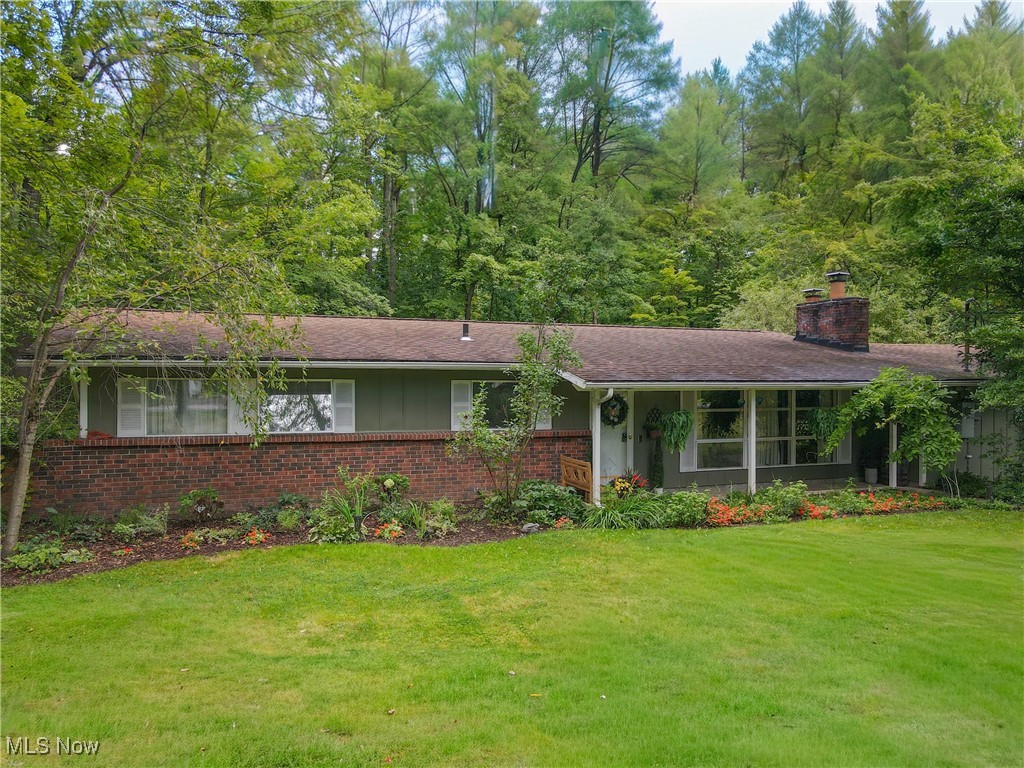 Thoughtfully updated 3 bedroom 2 full bath ranch offering easy single-story living! Step inside to a welcoming living room with a masonry wood-burning fireplace and a wall of windows that flood the space with natural light. The dining area boasts views of the back yard and a slider to the patio and is just off of the updated kitchen. Remodeled in 2020 the kitchen features quartz countertops, tile backsplash, Stainless dishwasher, microwave and wall oven, and a sleek cooktop with custom hood. There is a walk-in pantry with coffee bar that provides extra storage and plenty of room for coats and shoes. The laundry area offers flex space and is easily adaptable as a den or office. Located down the hall is the primary bedroom which includes an en suite bath,while the two additional bedrooms share a full bath. Outside, the expansive stamped concrete patio is perfect for entertaining-whether you're watching the game, relaxing in the hot tub, or enjoying views of the backyard. Sitting on just under an acre, this property backs up to nearly 53 acres known as the Modroo Preserve, offering both privacy and a natural backdrop. Located on a quiet street in the Award-Winning Chagrin Falls School District with Geauga County taxes and city water and sewer. Many updates:50 gallon hot water heater (2025), Updated electric panel with generator adaptor (2024), Exterior painted (2024),Hot tub and concrete hot tub pad (2024), Insulation (2023), Stamped concrete patio (2021), Interior paint (2019). Not to be missed!