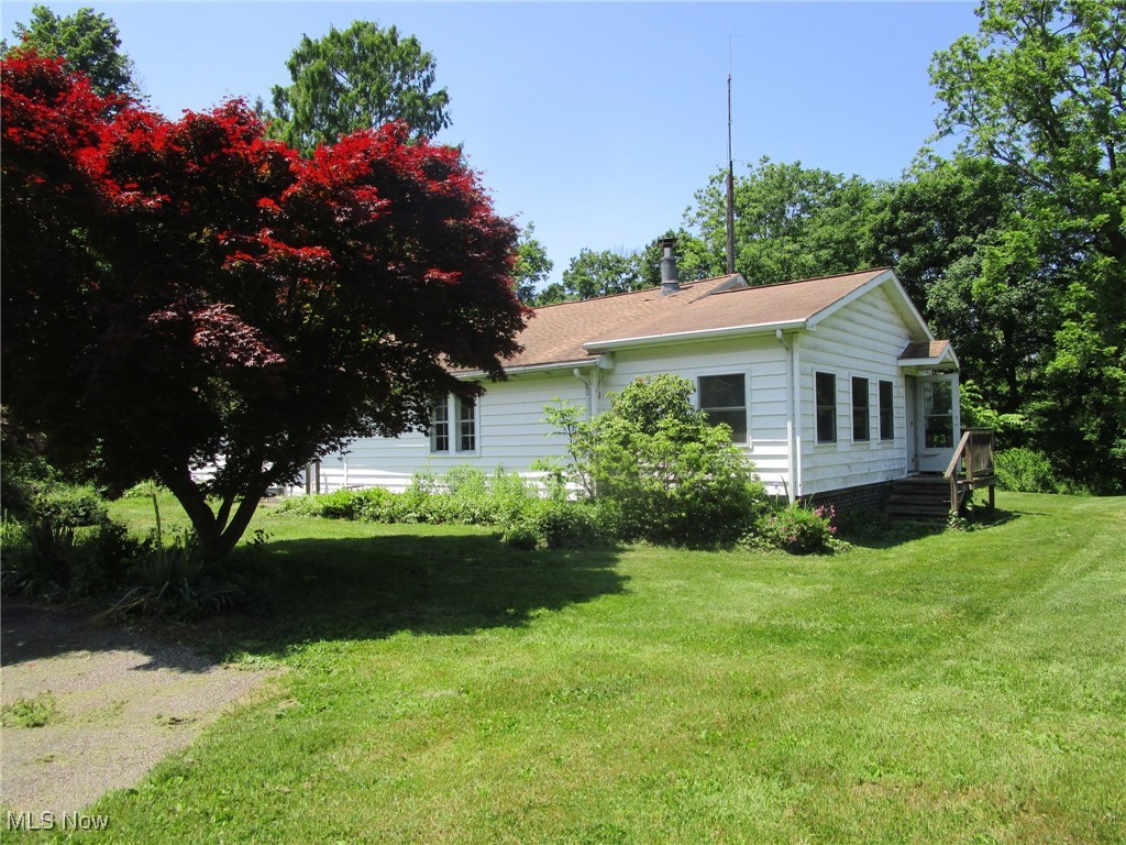 Conneaut Creek frontage!!! Do you live to fish!!? This just might be your dream property. Sitting on almost 7 wooded acres, this amazing hillside location provides a retreat-like setting & with its walk-right-into-the water frontage on the Creek, you'll never need to fish anywhere else! Teeming with wildlife (deer, turkey, rabbit & of course fish!), there's also an abundance of fruit trees (cherry, pear, apple & also some blueberry bushes). The woods are a nice mix & a rarity is the unique Bald Cypress, which the seller estimates is probably over a hundred years old.With Metro Parks property adjoining on one side & Conneaut Fish & Game just across the Creek, you'll enjoy an abundance of solitude all year round.Horse shoe drive offers plenty of parking space for your friends, family & visitors when they come for a weekend in the country. Inside you'll find the HUGE great room w/a WB stove & SO much room for entertaining, lounging, eating & telling fish stories. Enjoy a drink & a book sitting in the bright, cozy sunroom, or use it for extra sleeping/bedroom space for extra visitors. There's also a large foyer w/plenty of built in storage, a full bathroom on the first floor (& one in the basement!), a linen closet & a cool little hidden bedroom loft up above the great room. Two other bedrooms, formal dining room (w/ built ins & window seat) & the kitchen round out the space. Kitchen has currently been gutted, so bring your fun "lodge" kitchen counter & cabinet ideas & start your renovation. The great room has newer laminate flooring, the windows have all been updated to vinyl replacements, the furnace & water heater are newer & the electrical panel has been upgraded.There's also a delightful old barn (36x30 & needing repair), a 36x20 garage & a 22x18 carport. Roll up your sleeves, bring your tools & with a little bit of flooring, paint & effort, this little lodge will shine! Sold as is; the sellers will make no repairs. Stove, fridge and gas burning stove are excluded.