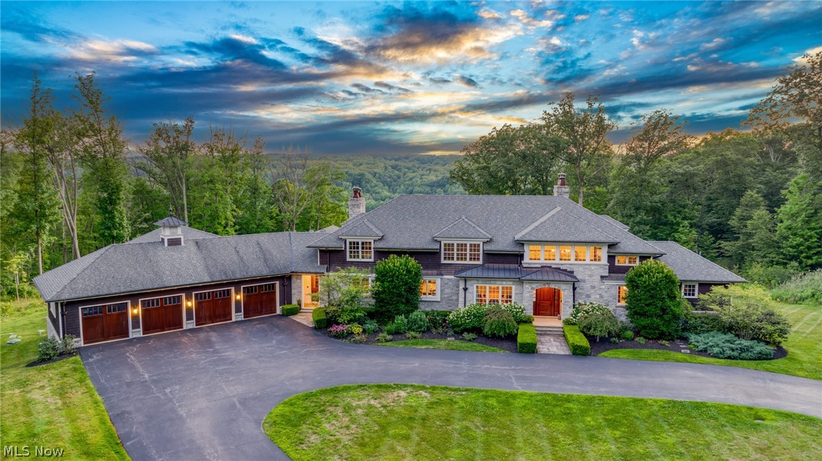 Spectacular panoramic views of the Chagrin Valley from this custom designed manor by Tony Paskevich. The exquisite attention to detail and meticulous care is unsurpassed. Since 2022 there have been numerous updates including fashion designer Christian Siriano’s tasteful touches throughout. Three levels, each over 4400 square feet, have been updated with impeccable and timeless design. In addition there is an indoor, full size gymnasium to enjoy year round pickleball, basketball, volleyball or any other wellness activity. The luxurious first floor owner's suite has gorgeous views, a stunning bathroom and a bedroom sized walk in closet with his and her islands! The two story foyer has an open staircase surrounded by detailed moldings and mahogany walls leading to the open loft area. The gourmet kitchen has a large island, commercial grade appliances, a 9' pantry and opens to a morning room / family room combination overlooking the valley. The living room emanates classic simplicity and the dining room is illuminated with a gorgeous RH chandelier. The family room accesses the beamed screened porch with a wood-burning fireplace leading to the terrace, both with heated floors. Every room has oversized windows to take full advantage of the views with a total of five fireplaces. The second floor has four bedrooms, 3 full baths, a bonus room and loft. The walkout lower level is unparalleled with a 16' mahogany bar, a gorgeous wood plank 10' ceiling, wine room with tasting area, a stone fireplace, drop-down projection screen, a fitness room, wellness room, spa bath with steam shower, bedroom with an ensuite bathroom and an office you can walk out to the oversized patio. The mahogany paneled mudroom has private lockers and opens to a huge laundry room with 2 sets of washers/dryers and opens to the 4 car heated garage. Sonos sound system thoughout and the finest of materials are endless including the geothermal HVAC system and tankless water heaters.