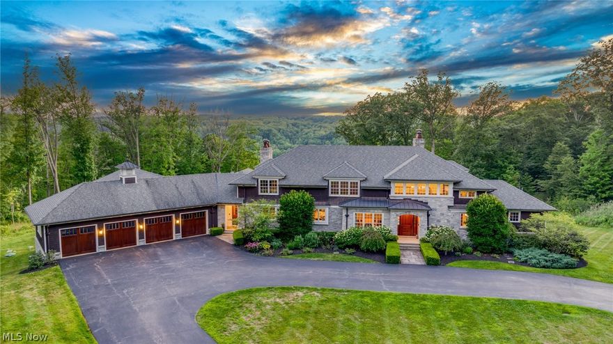 Spectacular panoramic views of the Chagrin Valley from this custom designed manor by Tony Paskevich. The exquisite attention to detail and meticulous care is unsurpassed. Since 2022 there have been numerous updates including fashion designer Christian Siriano’s tasteful touches throughout. Three levels, each over 4400 square feet, have been updated with impeccable and timeless design. In addition there is an indoor, full size gymnasium to enjoy year round pickleball, basketball, volleyball or any other wellness activity. The  luxurious first floor owner's suite has gorgeous views, a stunning bathroom and a bedroom sized walk in closet with his and her islands! The two story foyer has an open staircase surrounded by detailed moldings and mahogany walls leading to the open loft area. The gourmet kitchen has a large island, commercial grade appliances, a 9' pantry and opens to a morning room / family room combination overlooking the valley. The living room emanates classic simplicity and the dining room is illuminated with a gorgeous RH chandelier. The family room accesses the beamed screened porch with a wood-burning fireplace leading to the terrace, both with heated floors. Every room has oversized windows to take full advantage of the views with a total of five fireplaces.  The second floor has four bedrooms, 3 full baths, a bonus room and loft. The walkout lower level is unparalleled with a 16' mahogany bar, a gorgeous wood plank 10' ceiling, wine room with tasting area, a stone fireplace, drop-down projection screen, a fitness room, wellness room, spa bath with steam shower, bedroom with an ensuite bathroom and an office you can walk out to the oversized patio. The mahogany paneled mudroom has private lockers and opens to a huge laundry room with 2 sets of washers/dryers and opens to the 4 car heated garage. Sonos sound system thoughout and the finest of materials are endless including the geothermal HVAC system and tankless water heaters.