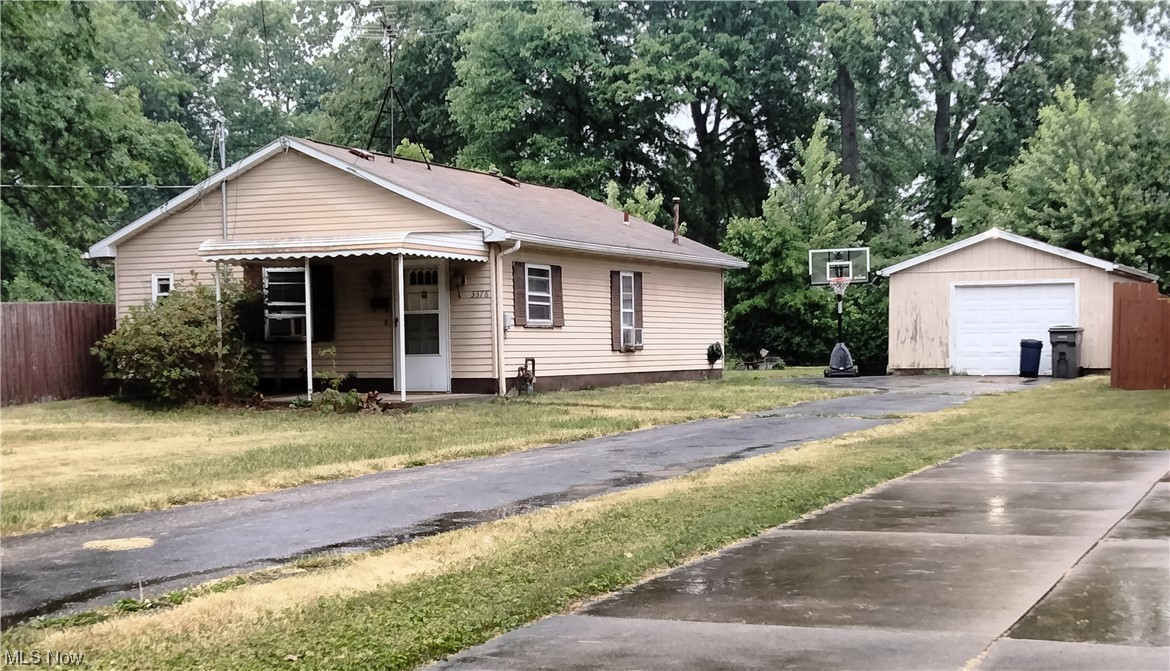 On a quiet street and one block of Austintown is this Mid century 2 bedroom, 1 bath ranch home sits deep into the yard and far off the street . Private fenced-n backyard on two sides, one is wood privacy, and rear is chain link, with room to build onto the house or garage. Enjoy one floor Condo like living, No steps here for half the price and privacy! An inviting concrete front porch greets you and leading to a spacious Living room which open concept floor plan into the kitchen with L-shaped oak cabinets, ceramic floor, a breakfast bar island , a stainless sink, range ,refrigerator and panty closet. Two bedrooms with large closets in both. First floor laundry room with laundry tub. Full bath with ceramic shower tub. Pull down steps to the attic for storage and the furnace is upstairs. Hallway from the kitchen to concrete patio and yard. Newer one car garage with door opener and man door, lots of parking space on the long blacktop drive and double wide at garage. Great ec