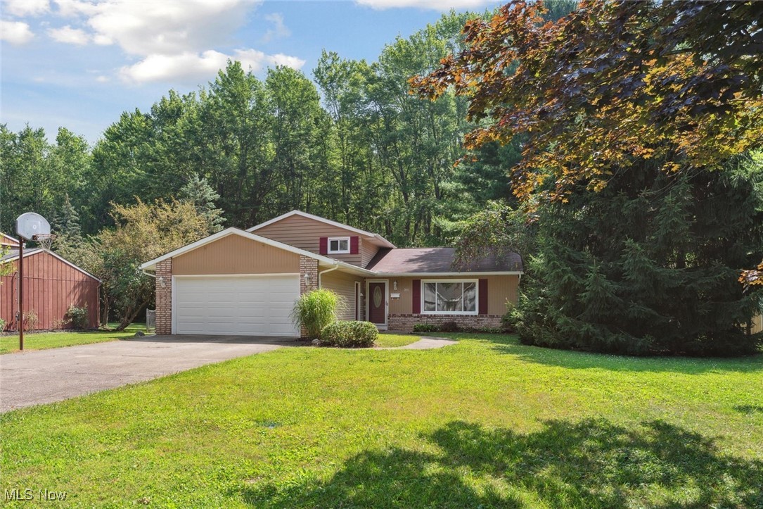 This charming split-level home, tucked away on a dead-end street, is located on a spacious lot offering beauty and privacy with trees and woods along the rear of the property. Conveniently located within walking and biking distance to Oberlin College and downtown, this neighborhood offers a unique path to enjoy the mile-long community trails to the north for your daily walks. An efficient layout begins with entering the main level into an open, bright, and large living room with beautiful views to the front and rear yards, an adjacent dining room and kitchen. The dining room opens to a generous deck, perfect for outdoor gatherings and outdoor dining. The kitchen includes all appliances, has plenty of countertops and cabinet spaces, and is large enough for a small dining nook if you prefer it for everyday meals. The upper-level features three comfortably sized bedrooms and a full bath. Downstairs, you will find a versatile family room with a fireplace to gather around, a hobby space, a utility and laundry room, and a full bath with a walk-in shower – offering room to spread for family and guests. Parking is easy with a front-facing two-car attached garage, a true bonus for Ohio weather! Other desirable features include fresh, neutral paint throughout, neutral new carpet on all carpeted areas, removed and repaired walls where the obsolete electric baseboards were present, central air, bonus tool shed, a fully fenced yard for pets or children, established perennial beds around the house, and a one -year home warranty for the Buyers! Move-in ready - schedule your virtual or in-person tour today!