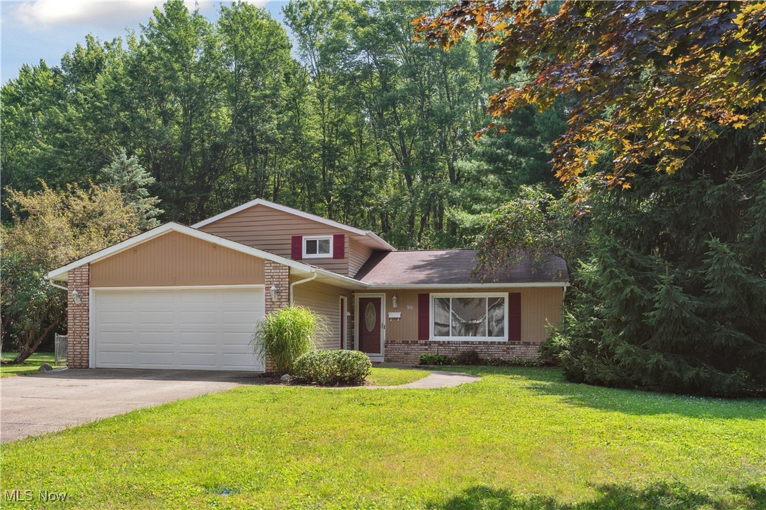 This charming split-level home, tucked away on a dead-end street, is located on a spacious lot offering beauty and privacy with trees and woods along the rear of the property. Conveniently located within walking and biking distance to Oberlin College and downtown, this neighborhood offers a unique path to enjoy the mile-long community trails to the north for your daily walks. An efficient layout begins with entering the main level into an open, bright, and large living room with beautiful views to the front and rear yards, an adjacent dining room and kitchen. The dining room opens to a generous deck, perfect for outdoor gatherings and outdoor dining. The kitchen includes all appliances, has plenty of countertops and cabinet spaces, and is large enough for a small dining nook if you prefer it for everyday meals. The upper-level features three comfortably sized bedrooms and a full bath. Downstairs, you will find a versatile family room with a fireplace to gather around, a hobby space, a utility and laundry room, and a full bath with a walk-in shower – offering room to spread for family and guests. Parking is easy with a front-facing two-car attached garage, a true bonus for Ohio weather! Other desirable features include fresh, neutral paint throughout, neutral new carpet on all carpeted areas, removed and repaired walls where the obsolete electric baseboards were present, central air, bonus tool shed, a fully fenced yard for pets or children, established perennial beds around the house, and a one -year home warranty for the Buyers! Move-in ready - schedule your virtual or in-person tour today!