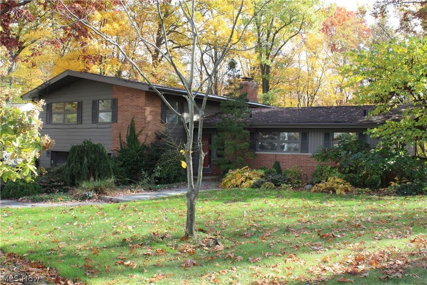Welcome to this well-maintained, lovingly updated four-level split on a picturesque, quiet street in West Akron. Bordering Sand Run park, this home is filled with windows taking advantage of the gorgeous views. This is the type of home you can picture yourself enjoying throughout the seasons. Walking out your back door and taking in the kaleidoscope of colors as you hike through the woods. Building a roaring fire in the living room, sipping hot cocoa, and watching the snow cover the trees. Rediscovering the backyard as lush greenery and flowers explode in the spring. And enjoying a glass of iced tea on the patio, even on the hottest days, appreciating the shade the mature trees provide.  Turning your attention indoors (although that may be hard to do) the kitchen houses top quality appliances and a large eat-in area. The lovely dining room can hold a large dining suite for hosting family dinners, and opens into the living room with a fireplace surrounded by built-in storage cabinets.