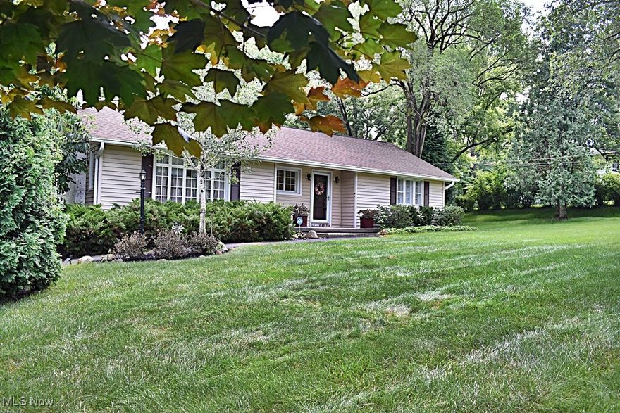 Charming, adorable, immaculate all describe this wonderful home...AND all on a 1.15 Acre lot! Enter into the large open Foyer with hardwood flooring and unique curved wall and you'll have a view of the over-sized Living Room with hardwood floors, wood burning Fireplace with blower / insert for those cozy evenings at home and large front window that allows so much natural light and views.  Living Room opens to the dining area also with hardwood floors.  Dining Room has access to the coziest Sun Porch area with views from every window!  The Dining Room also opens to the Kitchen with beautiful breakfast bar, natural wood cabinetry and back door that leads to a terrific deck, with retractable awning and those wonderful, wooded views of the back yard...imagine having your morning coffee and enjoying the private views that surround you!  All appliances will stay!  Two Bedrooms and a Full Bath will complete this level. Full Basement has a workshop / utility area, large pantry and a huge Recreation Room area with laminate flooring.  There's also a half bath with separate shower area in the laundry room.  Access to the one car garage is on this level. A storage shed offers even more storage. This home has it all!  Close to freeways yet minutes away from the MetroParks, Shawnee Golf course, shopping and entertainment. If that's not enough, Walton Hills Lake Club is available for membership.
