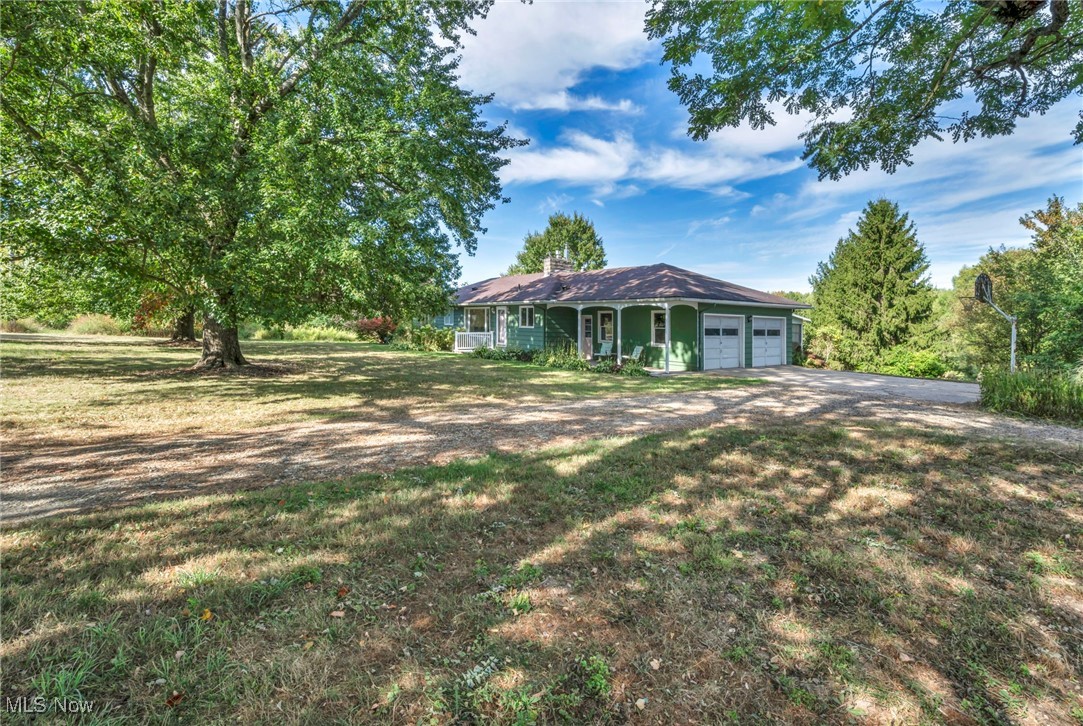 Welcome home to 2517 Hartville Road, a gorgeous 3 bedroom, 2 full bath ranch with a walk-out basement overlooking your 8.5+ serene acres. The property has undergone extensive updates that blend timeless craftsmanship with modern comfort in a park-like setting. When you first walk into the entryway you will notice solid hickory hardwood floors from Sheoga Hardwoods that span throughout the home. The fully applianced kitchen is outfitted with Ultracraft European-style frameless cabinetry. An open-concept dining area connects the kitchen & living room, offering tranquil views of the pond. Sliding glass doors lead to a spiral staircase that descends to the lower deck & access to a screened-in 3 seasons room, blending indoor & outdoor living. The main bathroom features hickory cabinetry, a two-person soaking tub/shower combo & stone tile floors warmed by electric radiant heat. The home includes three generously sized bedrooms & the master featuring his & her closets. Natural light pours into this home from all angles & views that can't be matched. The full walkout basement includes a full bathroom, laundry area, second kitchen, plenty of storage space, direct access to a flagstone patio at your private outdoor paradise, a wood-burning fireplace insert & ready for your finishing touches! The grounds have been extensively landscaped featuring a 1.6-acre pond stocked with trophy largemouth bass & bluegill. Several acres have been restored to native woodlands with maturing trees & winding trails throughout. The rear of the property borders Breakneck Creek, offering a peaceful natural backdrop. This nature-lover’s paradise offers year-round recreation- boating, fishing, ice skating, cross-country skiing & more. Heating & cooling are managed by a dual-fuel system installed in 2022, combining an electric heat pump for efficient climate control down to 32°F with a propane furnace for colder weather. Additional comfort is provided by zoned radiant ceiling heat. Call today!