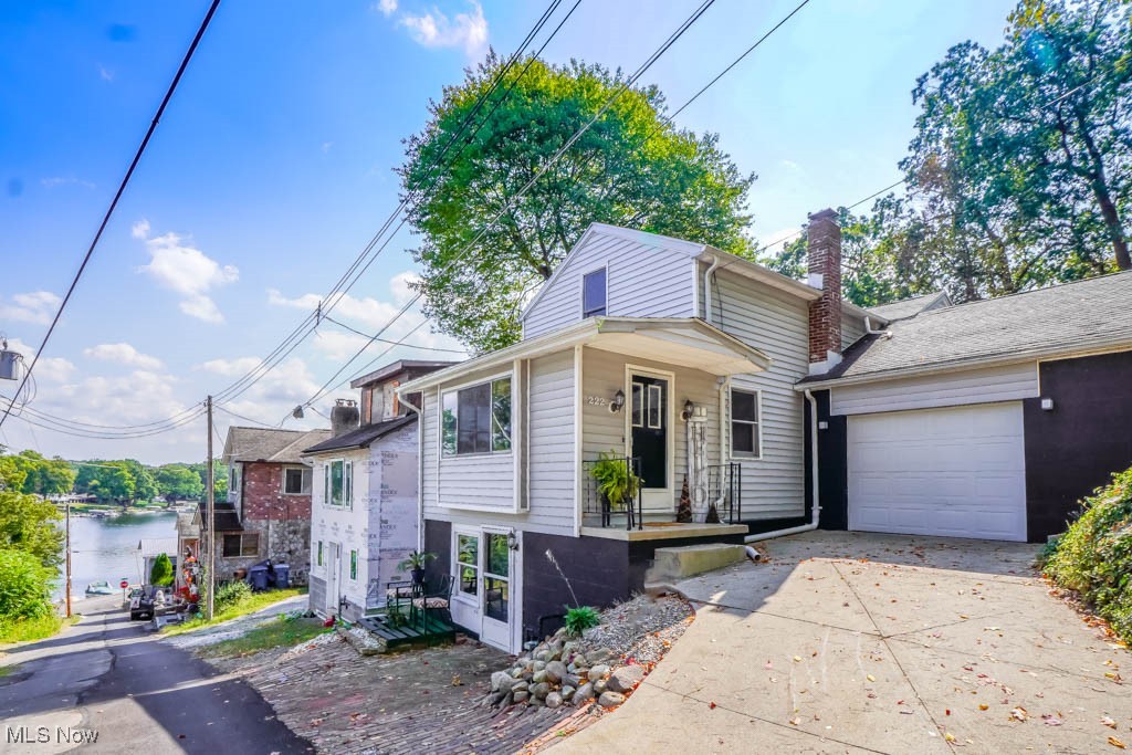 Whether you're searching for a full time home or a weekend retreat, this updated bungalow with lake views, a nice sized yard, and an attached one car garage is worth a look! Step inside to fresh paint and new flooring that continue throughout. The main level features a spacious living room that opens to the dining room with a beamed ceiling and knotty pine paneling, which carries into the eat in kitchen. A full bathroom is conveniently located nearby. Upstairs, you'll find two bedrooms with large closets and a beautifully updated bath with a corner shower and vessel sink vanity. The walk out lower level adds a rec room with patio access and lake views, along with storage space, laundry, and mechanicals, including a new furnace and A/C. Set near the East Reservoir of Portage Lake, you’ll be just minutes from swimming, boating, fishing, restaurants, shops, and Portage Lakes State Park. With so much to offer inside and out, this is the kind of home you won’t want to miss. Call today!