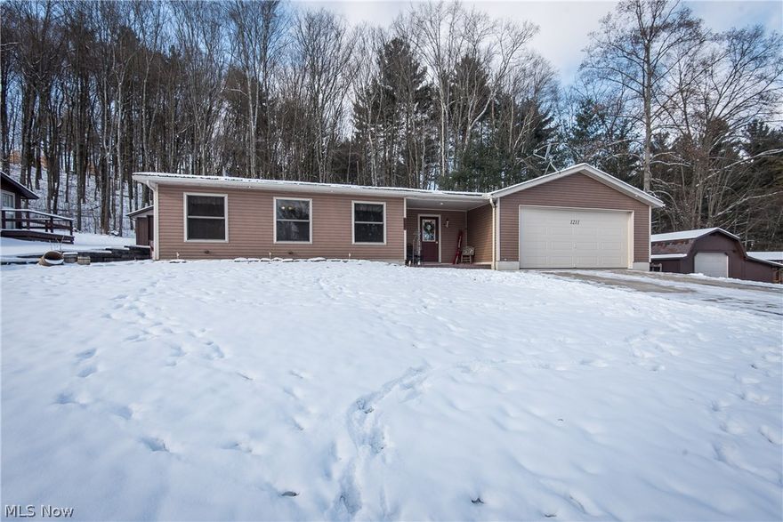 YEAR ROUND LAKE LIVING AT PARADISE POINT!  This cozy Atwood Lake ranch was made for entertaining and includes an aluminum dock that's just a short walk away.  The home features a cozy family room with sliding barn door and rustic wood paneling.  Step up to the open concept living room with wood burning fireplace and dining area, great for staying connected to family and friends while you're in the spacious kitchen with butcher block counters, laminate flooring and bar seating.  The master bedroom features a walk-in closet and patio door access to the deck.  Bedroom #2 has a cabin-like feel with paneled walls and ceiling.  The roomy full bath doubles as a first-floor laundry and includes tons of room for storage.  The attached garage has been converted to add even more living space with a sitting area with heated floors plus a kitchenette, tons of cabinets and partial bathroom with walk-in shower!  Enjoy the warmer weather hosting get-togethers on the large deck with hot tub and lighted