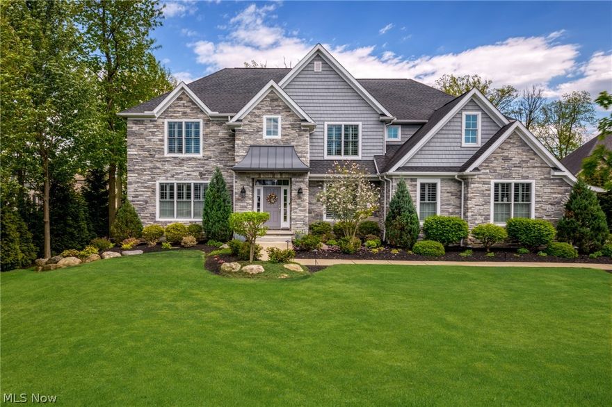 3179 Merion Ct- a masterfully crafted residence nestled on a picturesque cul-de-sac of distinguished custom-built homes. It is contemporary elegance exemplified with its modern color palette and stylish stone and shake siding. Professionally landscaped yard with irrigation system has mature evergreens, ample lawn area and abundant perennials and birch trees. Inside is just as alluring. A grand 2-story foyer with angled staircase makes for a dramatic 1st impression. Flanked by a formal dining room adorned with wood paneling as well as a versatile front office or 1st floor bedroom with adjoining full bath. A vaulted great room, bathed in natural light, shares a magnificent 2-sided stone fireplace with the rear sunroom. This bright and airy space offers panoramic views of the expansive yard. An open floor plan seamlessly connects the great room to the kitchen + dinette area. The gourmet kitchen boasts custom cabinetry, granite counters, top-of-the-line appliances, walk-in pantry and a large island with bar seating. Mudroom with wood cubbies, half bath and separate laundry room round out 1st floor. Upstairs hosts 4 spacious bedrooms each ALL with full CA Closet custom walk-in systems. The primary is a serene retreat with tray ceiling, generous walk-in closet and luxurious ensuite bath equipped with dual vanity, granite counters, soaking tub and glass enclosure tiled shower. Bedroom 2 offers a private bath while rooms 3 + 4 share a Jack-and-Jill bathroom with separate vanity areas. The lower level impresses with its high ceilings, amazing unfinished storage area and 1,627 sf of finished living space. Office area, rec room, fitness room + half bath! Oversized 3 car garage is a dream with its spectacular storage systems. Outside, a gorgeous brick paver patio with fire pit and stone seating overlooks a beautiful lawn with wooded backdrop. This Bennett Builders crafted home combines sophisticated design with practical amenities - all near Lakewood CC, Crocker Park and more.