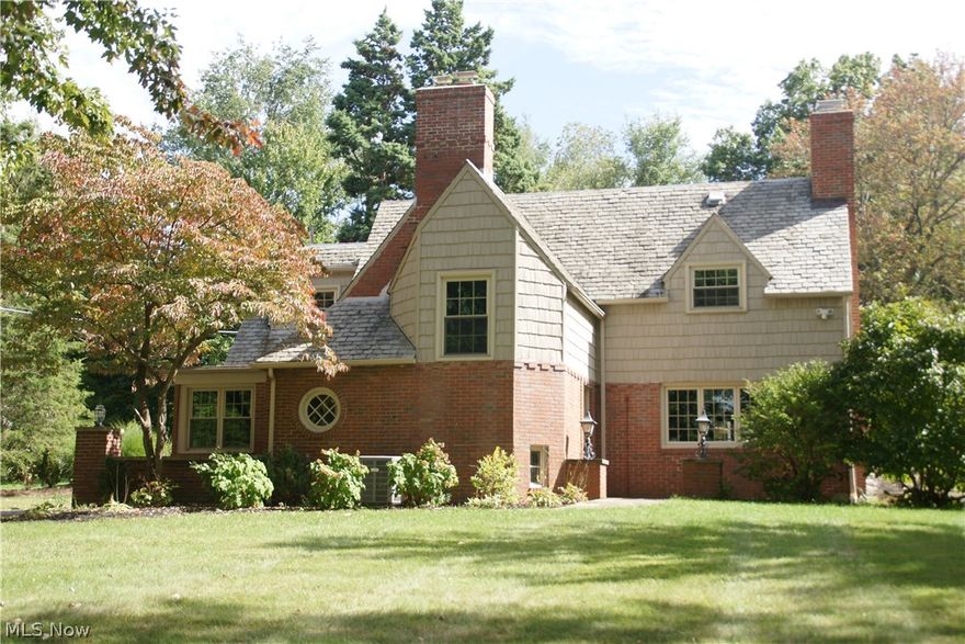 Outstanding AVONDALE Tudor home on large wooded lot and treed street. Entertain on the large patio with outdoor kitchen and fire pit area. Move-in ready with all the charm and details of a beautiful and unique family home. Living room has brick fireplace, hardwood floors, wood beams in ceiling open to the formal dining room.  Dining room perfect for entertaining with spacious built-ins.  Updated eat-in kitchen with corner windows and granite count tops.  Laundry/mudroom off large sun room.  Finished Rec room on lower level perfect for additional living area.  Many updated have been added including high efficiency furnace and A/C units, hot water tank and softener, insulation, windows, and vinyl siding.  Convenient to highway, schools and shopping.  You must see this home to appreciate it's character and location.