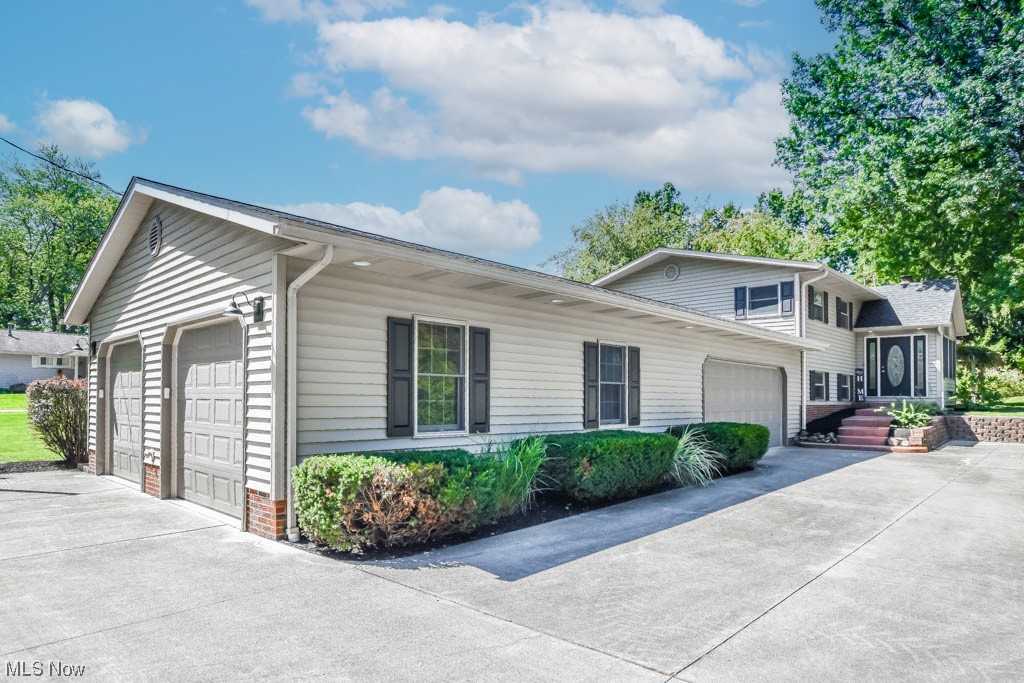 This beautifully remodeled 4 bedroom, 2 full bath bi-level with a 4 car attached garage is a rare find in Jackson schools! Some of the many improvements include a new roof, two garage door openers, electric panel, plumbing, flooring, lighting and so much more. A vaulted foyer welcomes you inside to the open concept living room, dining and stunning kitchen featuring granite countertops, stainless steel appliances and subway tile backsplash. A sliding patio door reveals a sun filled 3 season room with panoramic views of the backyard plus access to the patio with a pergola draped in grapevines. Three of the bedrooms are on the main level as well as a refreshed full bath with double sinks and tub/shower combo. The lower level adds an amazing master suite complete with a fireplace, two walk-in closets and a private full bath with two sinks and a 5' tiled shower. This level also features a spacious rec room with new carpet, laundry area and an abundance of storage. Car enthusiasts will appr