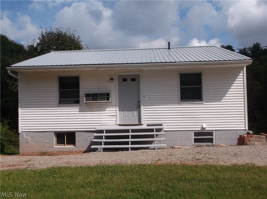 PRIVACY, HUNTING, FISHING - OH MY! This 2-3 bedroom home sits on a scenic 5.15 acres with stocked pond with pond aerator. The living room and eat-in size kitchen offer an open concept both with new vinyl flooring. Two bedrooms are located on the first floor with the third bedroom on the basement level all with large closets.  The spiral staircase leads to the basement level which can be used as a family room or game room ready for a wood stove, if desired.  A second bath is located in the basement but has not been hooked up. First floor washer and dryer included. Many updates include some new flooring, beautiful wood wall décor, all new kitchen appliances, ceiling fans, some new paint (interior and exterior) and new metal roof. A portable "garage in a box" has been installed on a concrete pad for additional storage. Well, water holding tank, private septic. Mineral rights are leased but may be negotiable. (Auditor reflects address as 52595 Dog Run Road.) Move-in ready country living no