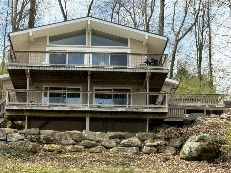 WONDERFUL LAKEFRONT HOME with 199 feet of arching lake frontage overlooking absolutely some of the nicest views of Lake Buckhorn. This 3 bedroom, 3 FULL Bath updated home with desirable Split Bedroom Floor Plan has some of the most interesting natural rock outcroppings as well as a tremendous amount of man-made, retaining rock walls. This home has been a full-time home for the owners, but would make a wonderful weekend Lakehouse home if that is what you are looking for. The kitchen has been remodeled w/ a Large Leather-Feel Granite Island accented with stained cabinets to provide a perfect contrast to the white cabinets throughout the rest of the kitchen. The kitchen's high ceilings are adorned with 400 year-old Native American Wormy Chestnut beams(none of this species now exist) built into the Massive 9ft x 4 1/2ft Stone Fireplace that soars to about 12 feet high.Large intriguing beams are also on the other side of this Massive Stone Fireplace into the 19x17 Great Room with a pair of 8-foot sliding door and a pair of large trapezoid windows above the sliders overlooking the Lake.  The sides walls of the Great Room have walls of windows on both sides of this room. The sliders walk out to a 31‘ x 9‘ deck calmly and relaxingly overlooking the Lake. The deck also wraps around the other two sides of the house and actually out to the massive stone walkways to the driveway. There is an inviting antique brick patio among the large rock retaining walls and a barbecue area. On the lower level is another Family Room with a Wood-Burning Stove and another pair of 8-foot sliders out to a lower level deck again overlooking the Lake and Large Lakefront Lot. The Epitome of interest for this property however, is THE VIEWS!!! They’re both long and wide w the arching lakefront lot overlooking the main lake, but the frontage bends in toward the inlet. There is composite Trex Dock w Power Boat Lift that you will love.     We all know the Age-old saying “LOCATION, LOCATION … LOCATION!!!”