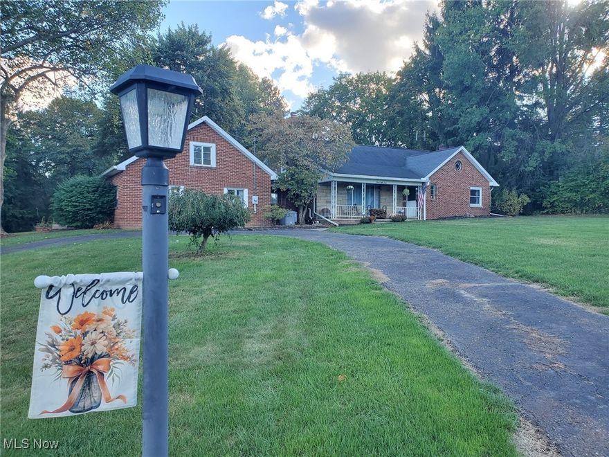 Fabulous Find! Welcome to the fall season with great views surrounding this charming 3 bedroom, 2.5 bath cape nestled on 2.36 acres! This beautiful brick & stone home features a front porch, inviting entry, spacious living room with a woodburning fireplace, open dining room & applianced kitchen with plenty of cupboards, a corner sink & coffee bar, a large 4 season sunroom/family room with sliders to the exterior as well as a 1st floor home office/bonus room near both family room & as an extension of the primary bedroom and 2 bathrooms. Bedrooms include a first floor bedroom as well as 2 bedrooms upstairs with another full bath. Upstairs boasts of a second floor walk-in attic and plenty of side storage space. Full basement includes an updated finished rec room/theater room complete with wood burning fireplace, built-in bookcases, movie projector & raised bar/kitchen for entertaining.  Lower level also features extra storage, laundry and walk-up access from basement to the backyard. Outside you will find a garden, firepit, koi pond with waterfall, covered back patio complete with porch swing & side patio, woods, a ravine, plenty of parking (including RV parking), a 2 car attached garage AND a long private driveway back to an extra 2 car garage (18x22 plus 17x30) with metal roof & concrete floor. Some of the many updates include: pressure tank (2024), dishwasher (2024), water softener (2021), living room fireplace insert (2021), lean-to garage (on right of extra outbuilding 2019), hot water tank (2019), some newer windows & sewer (2016). You will FALL in love with all this property has to offer.