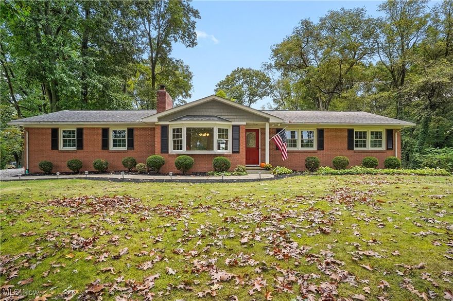 Come fall in love with this well-maintained property nestled on a 1 acre wooded lot. This cozy 3-
bedroom, 2-full bath home offers a peaceful retreat with 3 fireplaces, 2 gas and one woodburning.
The kitchen is a chef's dream, with natural hickory cabinets and ample storage that adds
warmth and character. The property features a spacious family room addition added in 1997,
with vaulted ceiling and windows to let in natural light and seasonal picturesque views of the
Nimisilia Reservoir. Retreat to the large deck and patio area, perfect for relaxing in a quiet
space or entertaining with a built-in natural gas grill. The walk out basement features 5 rooms
including a family room, full bath, laundry space, and a possible office or 4th bedroom, also
boasting a handyman’s dream workspace.  With its tranquil setting and added living space, this
home is an ideal blend of comfort and nature. Perfect for those seeking a cozy home in a
beautiful park-like setting in the Green School District. Schedule a showing today!