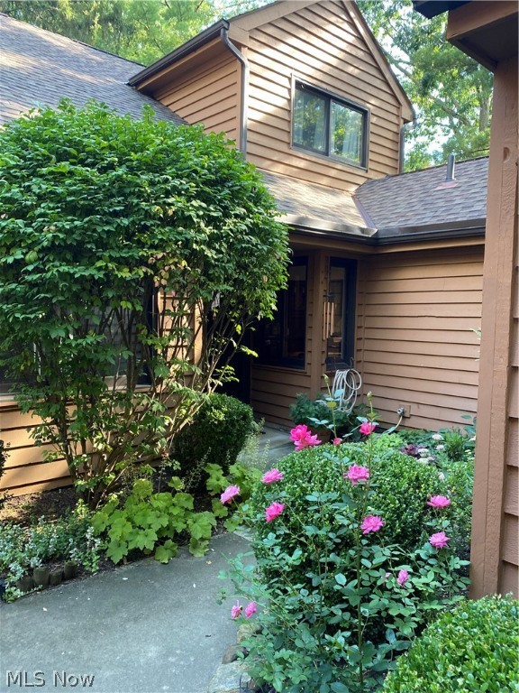 Step into the beautifully updated Cap Cod style condo located in down a private road in Greenwood Village, set on a corner lot overlooking a wooded scene with a creek below accenting the landscape! As you step into the private entrance off a courtyard, to the left is an office, den, or potential bedroom with closet space. The eat in kitchen offers stainless steel appliances, quarry stone floors, stamped counter tops and beautiful dark wood cabinetry. Quick access to the two-car garage, laundry room and half bathroom are located just off the kitchen. The highlight of this home is the combined living room and dining room featuring wooden beam accents, etched cut glass windows and a warm gas fireplace. The back porch offers views of the wooded landscape and is just minutes from the Cuyahoga Valley National Park. The main bedroom on the first floor has a private bathroom and large closet. Upstairs has two bedrooms and a full bathroom with ample storage throughout. Attic access is through t