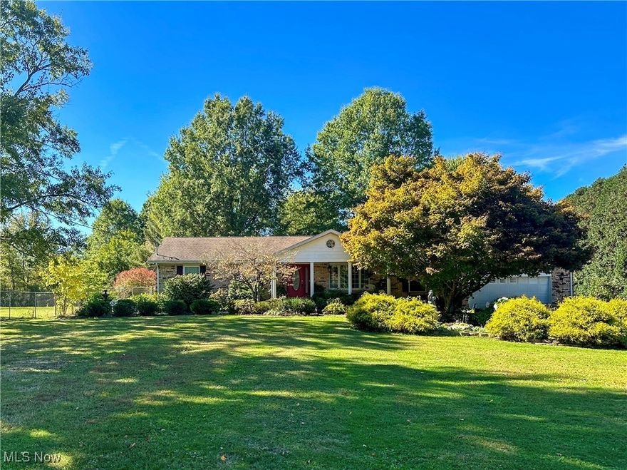 Discover your own slice of paradise with this wonderful brick ranch set on a sprawling 2.75 acres of parklike grounds. The backyard is an oasis featuring a large deck, a covered patio, a charming gazebo, a pergola, and an arbor, all surrounded by lush perennial landscape and shady trees. The tranquil sound of the koi pond and the gentle chirping of birds create a serene atmosphere perfect for relaxation or entertaining. The impressive 48x24 barn serves as both a workshop and storage space, providing ample room for hobbies or projects. With plenty of space to play, unwind, and immerse yourself in nature, this property is a true retreat from the hustle and bustle of everyday life. Inside, pride of ownership shines through in every detail of this 1,653 square foot home. Gleaming hardwood floors, meticulously crafted and installed by the owner, lead you through a spacious living room featuring a cozy fireplace, perfect for gathering with loved ones. The dining room flows seamlessly into a fully equipped kitchen with a center island, ideal for culinary adventures. A stunning sunroom with a cathedral ceiling and walls of windows offers a bright spot to enjoy your morning coffee. With three comfortable bedrooms, two full baths, and a finished basement that includes a recreation room, bonus room, storage space, and a large laundry area with a shower, this home is designed for both comfort and functionality. Custom woodwork, crown molding, and a beautifully crafted fireplace mantle showcase the owner's expert craftsmanship, making this home not just a place to live, but a work of art. Best of all, you get to enjoy the advantages of peaceful small-town living with close proximity to all amenities, including shopping, restaurants, recreation, and the Youngstown Warren Regional Airport.