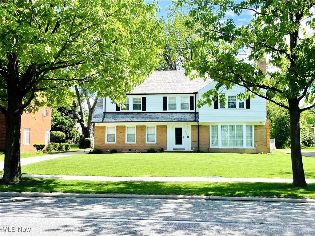 Welcome to this distinguished Shaker Heights residence, where timeless elegance meets modern comfort. Nestled in a coveted neighborhood, this architectural masterpiece showcases refined charm alongside thoughtful upgrades. Step into the grand foyer, where a graceful curved staircase sets an inviting tone. The beautifully updated eat-in kitchen features granite countertops and SS appliances, blending style and practicality. A stunning library with built-in bookshelves provides a cozy retreat, ideal for a home office or reading nook. Sun-drenched bay windows fill the spacious living room with natural light, highlighting a striking fireplace—perfect for relaxation and entertaining. Formal dining room offers ample space for hosting memorable gatherings. Gleaming hardwood floors flow throughout most of the home, including the upper level, enhancing its warmth and character. Sunroom offers a peaceful escape, opening to a new composite deck and a sprawling fenced backyard—a private oasis. Upstairs, 4 generously sized bedrooms await, including a luxurious primary suite with an ensuite bath. Storage is plentiful, with ample closets. Finished lower level presents another inviting living area, complete with a fireplace, full bath, and additional storage. Modern updates include a newer hot water tank, a well-maintained HVAC system, and a beautiful slate roof. The attached 2-car garage, discreetly tucked at the rear, boasts a Nature Stone floor for an elegant touch. Located just moments from the vibrant Van Aken District, this home provides convenient access to premier dining, workspaces, and year-round events. Rapid transit, playgrounds, golf courses, and top-rated schools—including Fernway Elementary, Lomond Elementary, and St. Dominic School—make daily life seamless. Point of Sale (POS) compliant as of April 2025, this exceptional home is move-in ready. Conveying appliances include a dishwasher, dryer, microwave, range, refrigerator, and washer.