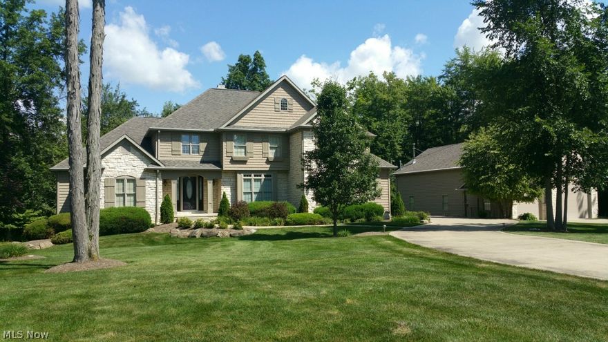 Absolutely stunning 2-story with full walk out basement, and huge hobby building nestled on over 2 scenic wooded acres. Dramatic 2 story great room is complimented with window wall, gas fireplace and beautiful built-in entertainment cabintry. The custom eat-in kitchen includes breakfast bar, hard wood flooring, stainless steel appliances and granite countertops. Many custom amenities throughout to include gorgeous Brazilian Cherry flooring. First floor formal dining room with tray ceiling, laundry room, sun room overlooking maintenance free deck. Spacious 1st floor Owner's suite with trayed ceiling, glamour bath with glamour tub and large tile shower, walk-in closet. Beautiful staircase leads upstairs to loft, private guest suite, 2 additional bedrooms with jack-n-jill bathroom. Professionally finished walk-out lower level includes a recreation room, fabulous bar/kitchen, bedroom/office, full bath and ample storage. Perfect set up for a potential in law suite or the entertainer. Outsid