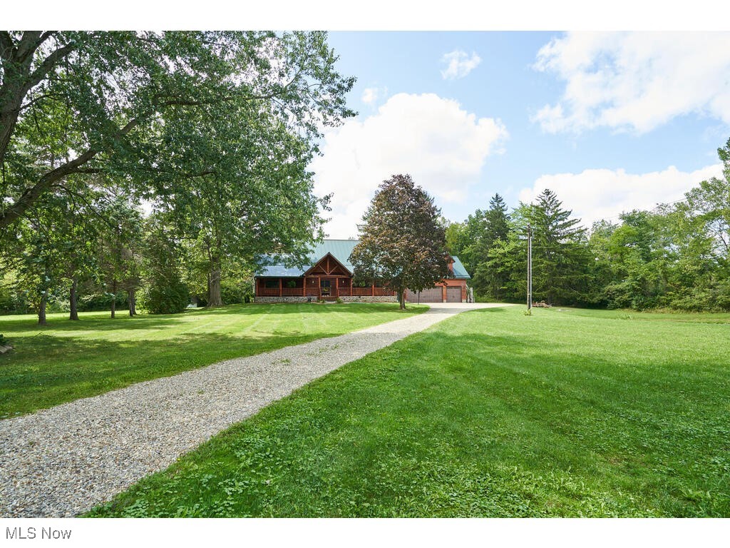 Wonderful home with many updates on 1.38 acre lot with pond, privacy and a 3 car garage. Call to see this log front, vinyl exterior ranch with a metal roof. It appears to be a 2 story because of the high roof line- but it is a ranch. A stone floor foyer welcomes you into this home. Kitchen with updated maple, self close cabinets, stainless steel appliances, and laminate floors. Living room and dining open from the kitchen. Dining can fit a banquet size table. The living room has an electric fireplace which can stay with the property. The family room is 3 steps down from kitchen and has soaring ceilings, with 2 ceiling fans, also an electric fireplace (that can stay with the property) and sliding glass door to the side. Off the living room- dining area is slider to a concrete patio with a pergola, and a built in grill. This is great space for family, entertaining and quiet times. Master bedroom with walk in closet. Other 2 bedrooms are carpeted. The Lower level has partially finished, w/ a carpeted rec room and walk up access to the garage. Off the 3 car garage is exterior steps that walk up to apprx 896 sq feet of unfinished space. This would be great space to finish as a studio, hobby room or even an apartment. There also is a large storage workshop area that was added to the back of the garage. This is accessed by double doors in the garage. Call to see this home today!