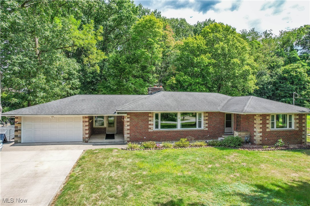 An amazing find! All brick ranch with 4 bedrooms, 2.5 baths, and nearly 3/4 of an acre of land. Step into a light filled living room with two large picture windows and a wood-burning fireplace with stone surround. The remodeled kitchen has space for dining, granite countertops, a tile backsplash, soft-close cabinetry, and stainless steel appliances including a wall oven and French door refrigerator surrounded by pantry cabinets. Down the hall are all four bedrooms with hardwood floors, including the primary suite with its own modern full bath and private access to the spacious deck and tree-lined backyard. The secondary bedrooms, one with knotty pine paneled walls, share an updated full bath with built-in linen storage. The waterproofed lower level adds a rec room with a convenient half bath, perfect for indoor gatherings. A mudroom connects the house to the two-car garage with a rear overhead door for easy backyard access and storage. Solid interior doors, new exterior doors, and updated furnace, A/C and windows make this home an easy choice. Schedule your showing today!
