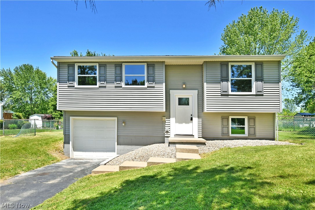 One look is all it will take to fall in love with this gorgeous Howland bi-level! Recently renovated from top to bottom and inside out, this stunner is move-in-ready and waiting to excite. Located in a desirable neighborhood the home sits off the road behind a row of tall pines, providing beautiful, natural privacy along with a scenic touch. Curb appeal continues with the warm gray exterior accented in bright white to include the engaging entranceway. Around the back, a raised wooden deck joins a sleek lower patio within the fenced-in yard. Inside, the brightly lit tiled foyer reveals the inviting staircase leading up to the main floor. Here, an open layout showcases its great room design with recessed lighting joining the sunshine to illuminate the living space. The must-see kitchen boasts sleek granite countertops with modern appliances and matching stainless sink. A large island offers easy prep space along with bar top seating if desired. Down the main hall, a handsome full bath provides an updated shower and stylish vanity. Three carpeted bedrooms complete the floor with personal closet space. Down below, a finished basement allows for a great family room experience with an additional half bath. Laundry and utilities are found down the short hall before garage access.