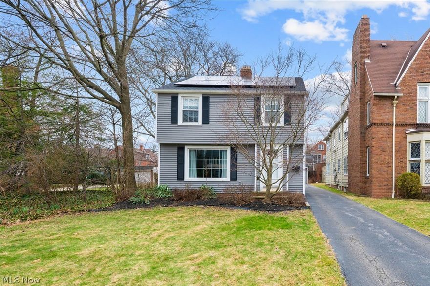 This classic Shaker Heights colonial offers a thoughtful layout & high-efficiency upgrades that provide immediate peace of mind, alongside the added benefit of an included adjacent parcel of land for extra space & opportunity. Step through the classic French door to be greeted by original hardwood floors that set an inviting tone for the entire home. The living room serves as a warm centerpiece with its functional gas brick fireplace & a large window that floods the space with natural light. From here, the home flows into the bright kitchen, which boasts ample cabinetry, included appliances & recently replaced skylights set between rustic wood ceiling beams. A convenient half-bath is located off the kitchen, while the kitchen opens into a formal dining room & a versatile flex-room addition, an ideal footprint for a sunlit home office or formal sitting room. Upstairs are three comfortable bedrooms & a full bath, including a unique bedroom with access to a massive full attic. It offers incredible potential for a children’s playroom, craft studio or seasonal storage. The finished basement expands the living space, featuring a second full bath, laundry area with included appliances & a freezer that stays, providing the perfect setup for a workout area, media room or private hobby space. Outside, sliding glass doors lead to a private wood deck, perfect for summer barbecues or morning yoga, alongside a detached two-car garage offering room for additional storage. The exterior is designed for easy living, featuring a new roof, siding & gutter guards (2023) & high-efficiency solar panels (2024). Combining sustainable energy with timeless character, this move-in ready home is a rare opportunity minutes from top-rated schools, parks & the vibrant Van Aken District.