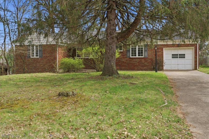 All brick ranch offers convenient city living. Sited on a beautiful treed lot with privacy this residence offers updated condition that include newer windows, roofing, and central vac. Mid century features throughout showcase handsome fireplace, hardwood flooring, paneled knotty pine study and original kitchen cabinetry. Full walk out basement with half bath, ample storage and summer kitchen. Private fenced back grounds with patio and mature landscaping. This efficient lifestyle home is available for showing today.