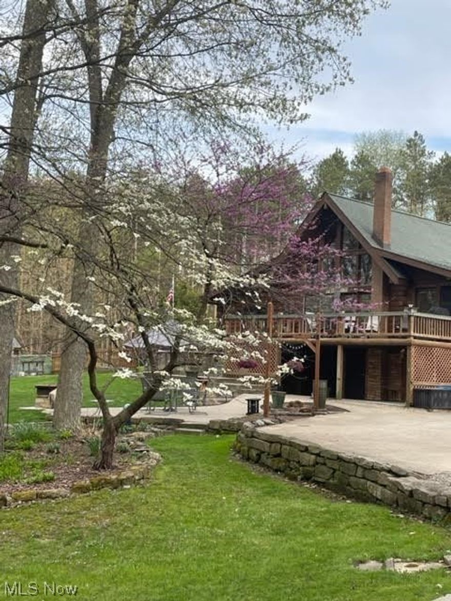 Stunning log home with private access drive to lake / dock at Tappan Lake. Home sits on nearly 7 acres with multiple outbuildings, beautiful landscape, fire pits, garden and finished bonus room above garage currently being used as an office.  This home features a gorgeous kitchen with granite counters, stainless appliances, abundant storage and floor to ceiling windows to enjoy the view with your morning coffee. There is a 4 season room off of the kitchen providing even more space to relax. There is a large deck, a patio with fire pit and a hot tub to enjoy the outdoors. The basement is partially finished adding another family room. Some of the updates include furnace  / ac (6yrs), HWT (2yrs), new master bath (2 yrs), roof (12 yrs).  There are also newer windows, sliding door, stair railing up to loft, paint and carpet.  If you enjoy hunting, boating, fishing or just sitting by the fire this is the place for you!! This one won't last, schedule a showing today!!!