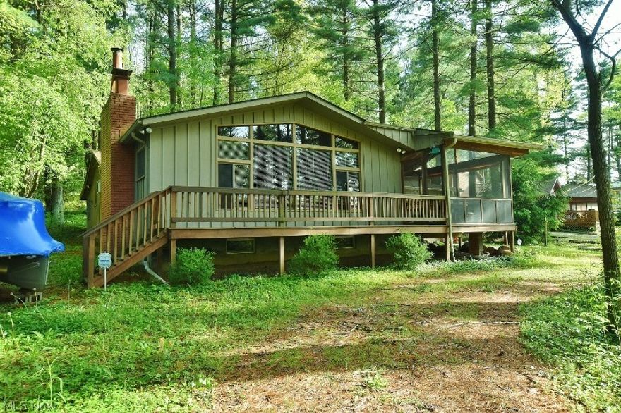 Enjoy all  the Atwood Lake area has to offer with this 2nd row, 3 bedroom, 1.5 bath ranch home with a 1.5 car attached garage. When your at the lake, you want to enjoy that outdoors, so you will be thrilled with all the outdoor living space including 1 large screened porch and deck on the front of the home offering limited lake views. On the back you will find a enclosed porch, screened porch and large stamped concrete patio all overlooked beautiful wooded grounds of the Atwood Pines community. Of course, what's a lake home without a dock? Your private dock is just a short walk from the front door offering you easy access to your nautical toys to get out and swim, fish or enjoy a leisurely cruise along the shores of beautiful 1540 acre Atwood Lake.  Once inside the home you are welcomed by a stunning 25x22 great room featuring a full wall of windows, vaulted knotty pine ceilings, a wood burning fireplace and wet bar. A large eat in kitchen provides a double wall oven, plenty of counter