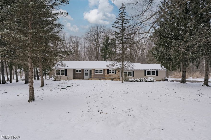 Welcome to this amazing, move-in ready ranch nestled on a generously sized lot with a peaceful, wooded front setting that offers both privacy and charm from the moment you arrive. Fresh white paint throughout creates a bright, clean canvas, while the home’s thoughtful updates and inviting layout make it perfect for comfortable family living and entertaining. Step inside to a welcoming foyer with ceramic tile flooring that flows seamlessly into the expansive open-concept living and dining area. This stunning space is filled with natural light, highlighted by two skylights, and anchored by a beautiful brick fireplace—creating the perfect gathering spot. Dual sliding doors lead directly to the back deck, extending your living space outdoors and making it ideal for hosting or relaxing evenings at home. The kitchen is both stylish and functional, featuring granite countertops, rich hardwood cabinetry, stainless steel appliances, and a convenient breakfast bar alongside a sun-filled eat-in area. Just off the kitchen, the laundry and mudroom provide practical everyday convenience with direct access to the attached garage and the basement. The private primary suite is thoughtfully positioned off the main living area and offers a spacious retreat with a vaulted ceiling, a large walk-in closet, and a well-appointed ensuite bath complete with a double vanity. On the opposite side of the home, three additional bedrooms provide ample space for family or guests, along with a second full bathroom. The partially finished basement expands your living space with a cozy rec room featuring a stone fireplace—perfect for movie nights, a playroom, or a home gym. Outside offers plenty of room to entertain, or simply unwind in your own private setting as well as a newly installed septic system(2026). This truly amazing home combines space and updates, in a beautiful setting.