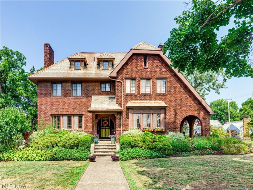 Character and class abound in this iconic Cuyahoga Falls home! This stately residence, in the style of an English Country manor, boasts 3,416 Square feet of finished living space, incl. 5 bed, 4 bath and office! Terraced landscaping and covered front door welcome you into a grand foyer w/gleaming hardwood floors that run throughout the home. Main floor features a fully renovated kitchen w/center island and breakfast bar. Gorgeous white cabinets, Stone countertops + updated appliances are just a few highlights of this stunning space.The kitchen overlooks the family room w/ brick fireplace+ built-in bookcases. Double doors take you back through the foyer into the living room w/ second fireplace, built-ins + access to the outside covered porch. A sizable dining room, half bath +mudroom round out this impressive first level. Second level can be accessed through the main center staircase or through the back staircase off of the kitchen. This Level features primary suite w/ walk -in closet, fireplace + ensuite bathroom! Two spacious guest rooms share access to the second full bathroom+ boast large closets + tons of natural sunlight. Third level has been finished to include a 5th bedroom, full bathroom +office. Exterior features of this home are impressive incl. 2 car garage w/ long wrap around driveway w/ two entrances, one off of 6th street and one off of Broad. Off the back entrance is a composite deck that gives access to a private courtyard w/brick pavers + mature landscaping. Stone pathways connect all the outdoor spaces and provide access to the terraced garden. The covered side porch is perfect for relaxing and entertaining .With access to the back yard and interior, it is a nice extension of the main fl. living! This home is nestled on a large corner lot but also features a side yard with privacy. Recent and notable improvements incl. full replacement of the Boiler  system + replacement of the garage doors (2024).