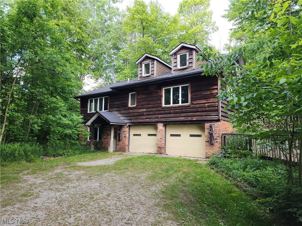 A diamond in the rough! Nestled on a 4-acre wooded lot, this unique custom home offers privacy & tranquility, set 900 feet off the road on a private shared driveway. Built in 1975, the interior boasts an old-world farmhouse charm, featuring authentic barn post & beam construction & genuine barn wood accents that add a touch of rustic elegance. 3 bed, 2 1/2 bath, eat-in kitchen, great room with wet bar & wood-burning fireplace, & a family room adjacent to the kitchen. The family room presents the opportunity for a 2nd first-floor master bedroom, allowing for flexible living arrangements. This property is being sold as-is. It requires some updates & repairs to unleash its full potential. The lower level boasts a walk-out design & includes 1 bedroom, a 1/2 bath, laundry room, a mechanical room, & storage. The home features an extra-deep attached 2-car garage with direct access to the lower level. There is an outbuilding with a loft. Embrace the rustic charm & envision the endless possibilities it holds. With renovations & your personal touches, this could be the home you've been dreaming of. Don't miss out on this incredible opportunity to make this property your own!