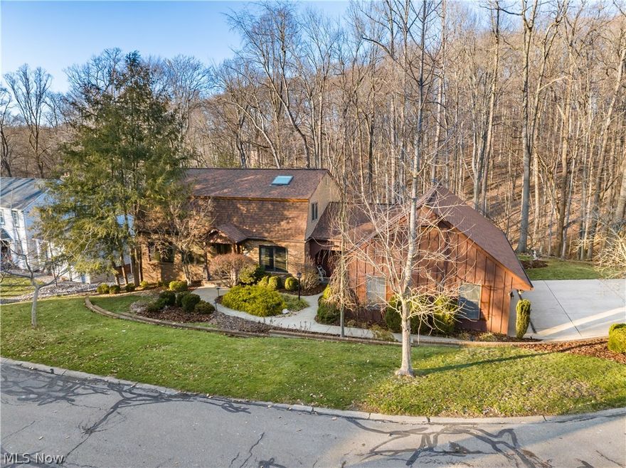 Nestled on a quiet wooded cul-de-sac, this beautifully maintained home offers privacy, natural beauty, and exceptional mechanical updates. The kitchen captures a broad view of towering hardwoods through an expansive window, bringing the outdoors in. Morning light filters through the trees, and everyday moments feel hushed and extraordinary. With the breeze drifting in and birds greeting the morning, the day begins with nature. In late summer and fall, evenings bring the steady chorus of crickets and soft evening bird song. The east-facing sun porch welcomes sunrise over the treetops. From there, deer are often seen grazing nearby or moving gracefully across the wooded hillside that rises before the home. Bright, open living spaces are framed by large Pella windows that enhance both energy efficiency and wooded views. An expansive deck extends the living area outdoors, offering a peaceful setting for gathering or reflection. The walkout lower level features a spacious recreation and game area with pool table and sauna. French doors open directly to the backyard and wooded setting, creating seamless indoor-outdoor flow. Significant updates include a new roof, new HVAC system, new hot water heater, radon mitigation system, Pella windows, new water softener with reverse osmosis (RO) system, and an automatic Generac backup power generator providing dependable peace of mind. Tucked into a tranquil wooded setting yet minutes from shopping, dining, grocery stores, and the hospital — a rare balance of seclusion and convenience.