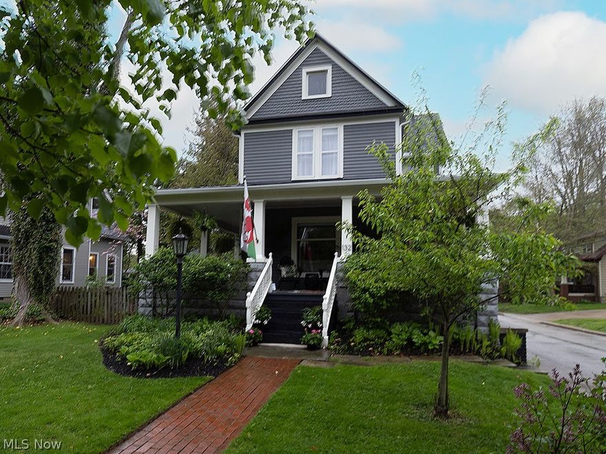 Welcome to this historic century home where thoughtful design meets everyday comfort. From the moment you arrive, the classic covered wraparound front porch invites you to slow down and settle in — the kind of space where mornings begin quietly and evenings linger a little longer.  Inside, warm hardwood floors, curated finishes, and a natural flow create a home that feels both elevated and effortless. The main level offers a beautifully balanced layout, including a welcoming living room with a gas fireplace, a dedicated dining or flex space, a private office or studio, and a fully remodeled bath.
At the heart of the home, the kitchen and gathering space have been carefully updated to blend style and function. A striking walnut waterfall island serves as both a centerpiece and natural focal point, complemented by granite countertops, a tiled backsplash, generous workspace, a large pantry, and an open wine rack. Just beyond, a spacious mudroom with built-ins keeps everyday living organized and easy.
Upstairs, all four bedrooms feature walk-in closets and exposed hardwood floors, creating light-filled, comfortable retreats. The primary bedroom features a custom accent wall that adds depth and character, creating a true sense of sanctuary.
The bathrooms offer a thoughtful mix of charm and modern convenience, from the spa-like shower to the character-rich vanity that brings warmth and personality to the space.
Outdoor living continues with a charming covered back area, a perfect spot for relaxing evenings or casual entertaining, along with a fully fenced yard and beautiful landscaping — creating an ideal setting to unwind or host after a day spent enjoying the village.
 Don't miss the incredible vaulted loft above the garage, complete with a cozy wood-burning stove and flexible space to gather. 
Recent updates include roof, furnace, air conditioner, and hot water tank, along with new concrete in the garage, light fixtures throughout, fresh paint, and wallpaper.