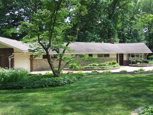 MID-CENTURY MODERN AT IT'S BEST!! Want a house that is NOT cookie cutter, with lots of interesting history? This is the house for you!! Ranch with 3 bedrooms, 1 large, full bath with 2 sinks and linen closet, eat-in kitchen with appliances, including original wall oven with original manuals (plus a modern oven). The large living room has cathedral ceiling, desirable and rare wormy chestnut paneling, woodburning brick fireplace and two walls of windows looking out at landscaped front yard and .783 acre backyard and stamped concrete patio. There is a "bonus" room that could be a small office or craft room or simply additional storage. Back of the house has first floor laundry/storage room that leads to the attached 2-car garage that was the original house. This garage has several extra "rooms" or areas for even more storage. In addition, at the back of the .783 acre is a 25x36 pole building with cement floor, electric, and 8-ft high garage door that could accommodate 6+ cars with