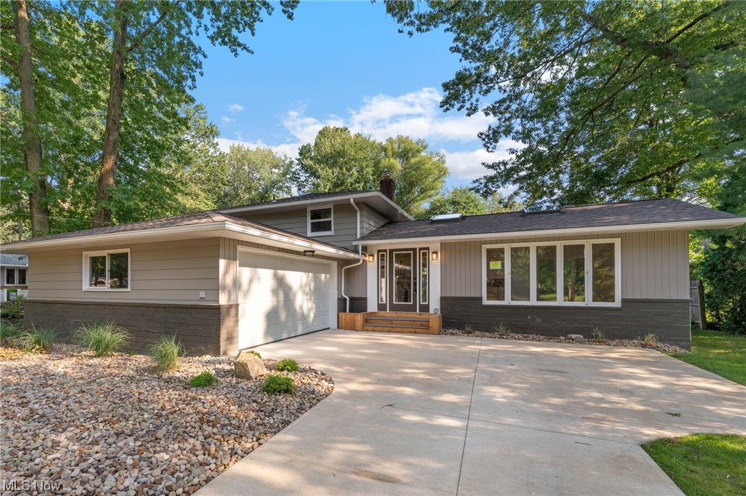 Welcome to this completely updated split level home. Upon entrance be greeted with the open concept living room with hardwood floors, beamed ceilings, and skylight windows. The Pintrest worthy kitchen boasts beautiful white cabinets, dark tile backsplash, and is equipped with a dry bar, large contrasting center island, and stainless steel appliances. Down a few steps from the kitchen is the family room that features a stone wood-burning fireplace and large sliding doors that lead out to the patio and deck area. Down the hall is a full bath and bedroom, a perfect place for guests. The second floor is home to the master bedroom with en-suite bath. The master bath is complete with new tile flooring, a dual sink vanity with LED mirror, and tub/shower combo. The 2 additional bedrooms have hardwood flooring, are equally spacious, and share the new full bath. This property will make a great home for its new owners. Don't miss your opportunity, schedule today!