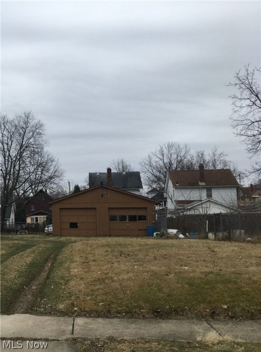 Two parcel vacant lot with two car garage on one parcel and chain link fence around second parcel. Currently used for a garden by neighbors (have permission).