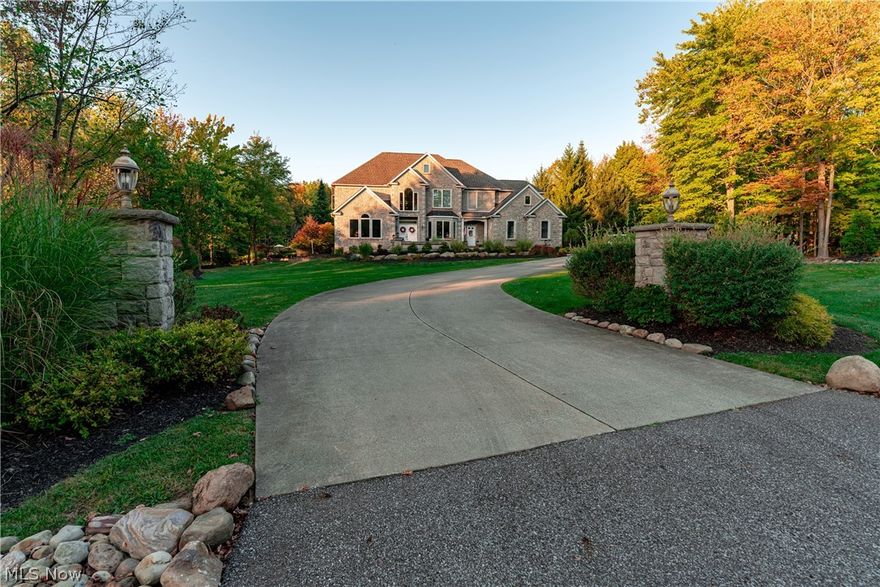 Nestled within the highly coveted Kings Forest development in the award-winning Revere School District, this exceptional estate offers resort-style living on nearly 3 private acres. Surrounded by mature trees, the outdoor setting is truly a retreat, highlighted by a breathtaking saltwater pool w/LED lighting, sheer descent waterfalls & a tremendous landscaped patio w/retaining walls, a fire pit, and ample space for lounging and soaking up serene wooded views. An inviting front paver patio sets the tone, offering a charming space to unwind before stepping inside to over 6,000 square feet of luxurious living space. The grand entry foyer with soaring ceilings opens to an elegant front living room, private office & formal dining room. In the rear is the 1st-floor in-law suite w/updated bath. At the heart of the home is the dramatic Great Room w/a floor-to-ceiling stone (gas) FP and a statement wall of windows. Expansive eat-in kitchen w/access to a new composite deck, and the four-seasons room w/gas fireplace and views of the stunning backyard. Upstairs, the enchanting primary suite offers a true escape w/a tray ceiling and ambient uplighting, complemented by a spa-like en suite featuring a jacuzzi tub, glass block walk-in shower w/dual heads, and his & hers WIC. Three add'l bedrooms each include walk-in closets, with one offering a private en suite bath and the others connected by a convenient Jack & Jill layout. A 2nd-floor laundry room adds everyday ease. The finished lower level is an entertainer’s dream, feat. a bar/kitchen, billiards room, home theater, wine cellar w/humidifier, gym w/gas fireplace, full bath w/walk-in shower, and a spacious rec room w/new LVP flooring. Completing the home is an oversized 4-car garage with direct basement access, along with an oversized shed/outbuilding. Control 4 Whole Home Audio (interior/exterior). Updated mechanicals, plus a reverse osmosis system & central vacuum. Your private oasis awaits - schedule your showing today!