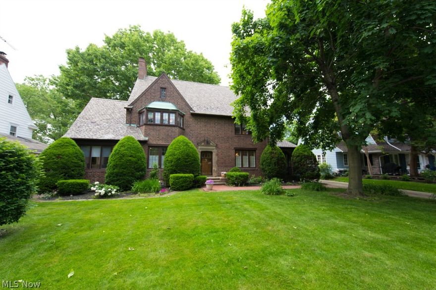 Stately English Brick Colonial w Tudor Elements! ***Check Out the 360 Degree Panoramic Virtual Tour!*** Architectural Detail Throughout This Magnificent Home! Grand Entrance with Gorgeous Curved Staircase! Spacious Living Room with Hardwood Floors, Beautiful Fireplace w/ Ornamental Mantel, Built-In Shelving, and Bayed Window! French Doors off of Living Room Lead to Darling Sitting Area! Charm Continues is the Large Formal Dining Room Featuring Ornate Crown Molding, Wainscoting, and Hardwood Flooring! Leaded Glass French Doors Open to Cozy Covered Porch! Sizable Updated Kitchen with Wood Floors, Newer Appliances, and Butler Pantry with Loads of Cabinet Space! Separate Breakfast Room! Half Bath on First Floor! Second Floor Features Master Bedroom w/ Hardwood Floors and Updated Master Bath! Three Additional Bedrooms w/ Hardwood Floors and Full Bath Complete the Second Floor! Amazing Third Floor Offers Two Additional Bedrooms, Walk- In Closet, and Full Bath! Leaded Glass Windows and Origin