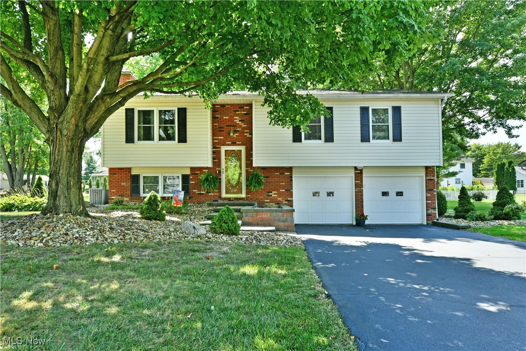 Find your forever home with this stunning Cortland bi-level! Captivating with two floors of beautifully kept and presented living space, this residence has been same family owned for nearly its entire lifetime, easily showcasing their meticulous care and attention to detail within every update. Nestled beneath the shade of colorful trees, the warm brickwork and raised stone walkway instantly draw you inside. A carpeted staircase rises from the foyer as the spacious living room enjoys its impressive open layout. Carpets continue down the main hall as natural light spills from the forward windows. Sleek hardwood styled flooring begins at the nearby eat-in dining room and flows throughout the kitchen. Elevated rear patio access is just steps away as you take in the backyard views. High polished stone countertops wind beneath a glass tiled backsplash as they divide the custom cabinetry and modern stainless-steel appliances. Down the main hall, a gorgeous full bath presents wonderfully as it highlights private access to the oversized master bedroom. The remaining two bedrooms bestow bright and colorful surroundings with plenty of personal closet space. Downstairs, a gracious family room steals the show, joining a white brick fireplace. A second full bath is located next to both laundry and garage access.
