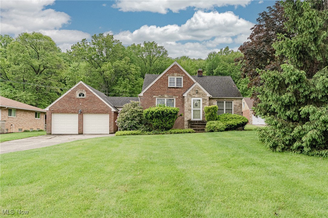 Welcome to 196 E Ridgewood Dr – A Picture-Perfect Seven Hills Cape Cod on a Spectacular Lot! This beautifully maintained 3-bedroom, 2-bathroom home blends timeless charm with modern updates, all set on an extra-deep lot that backs up to a serene wooded area – offering the perfect blend of privacy and space. Step into the inviting foyer and instantly feel at home as you’re greeted by the spacious living room, highlighted by gleaming hardwood floors, a stunning sandstone fireplace, and a large picture window that fills the room with natural light. The adjacent kitchen features tile flooring, and a cozy eat-in area– ideal for everyday living and effortless entertaining. Two comfortable bedrooms on the main level both feature hardwood flooring and are complemented by an updated full bath tucked between them. Upstairs, you’ll find a spacious and private retreat: a large third bedroom with warm wood floors and a walk-in closet complete with custom built-ins. The finished lower level expands your living space with a welcoming rec room, a second fireplace, built-in bar, and a full bath with laundry – perfect for game nights, guests, or extended stays. A delightful sunroom/mudroom connects the house to the attached garage and opens to the backyard through a sliding glass door, making outdoor living and indoor functionality seamless. The oversized garage also features a unique workshop area in the rear – ideal for hobbyists or extra storage. Step outside and enjoy the truly exceptional backyard – a deep, tree-lined lot that feels like your own private escape. Whether you're hosting a summer barbecue or simply enjoying the peaceful view, this yard is a rare find. Don’t miss your chance to own this one-of-a-kind gem in a prime Seven Hills location – schedule your showing today and fall in love!